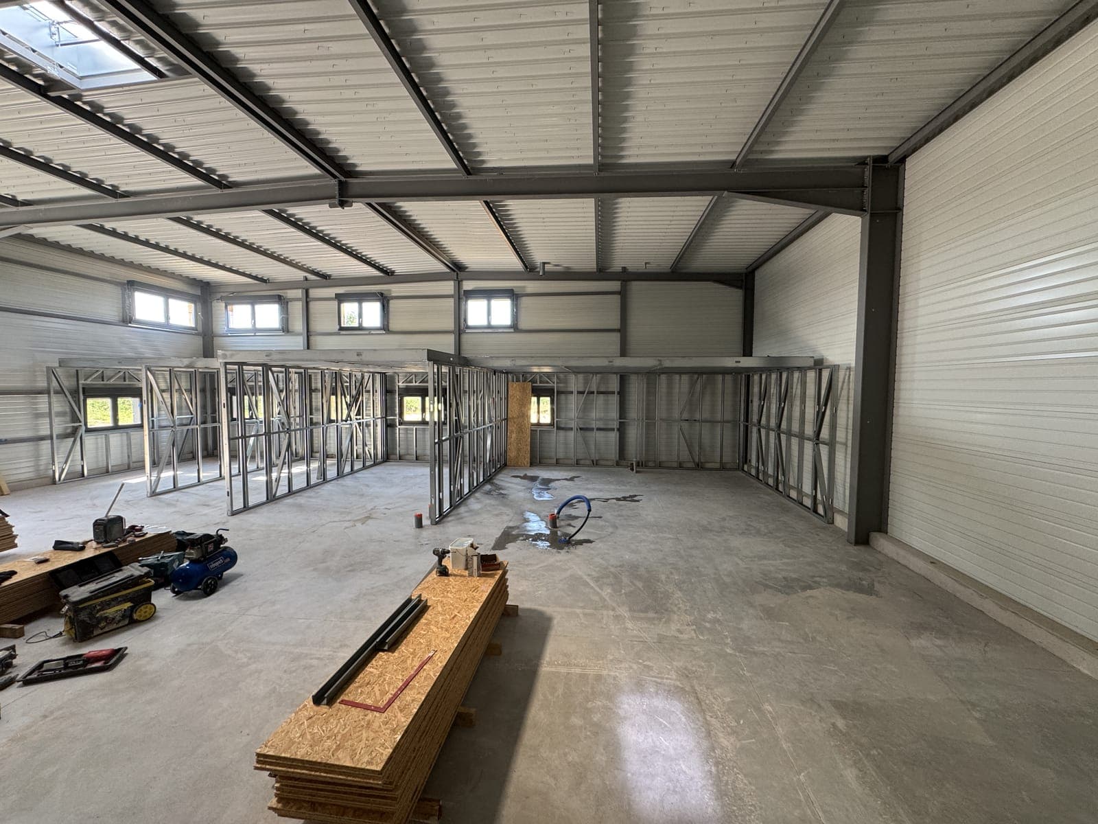 Cloisons et ossature des futurs bureaux créés dans le volume d'un hangar existant